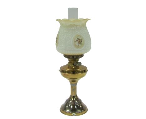 A 20thC oil lamp, converted to electricity, with a chimney, and a white and cream glass shade, with painted and transfer deta
