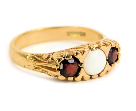 A 9ct gold dress ring, set with an opal and garnet, with raised scroll sides, maker JSM, Birmingham import marks, ring size N