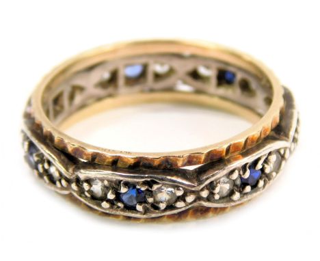 A wedding band, with a hammered gold coloured outer border, and white central oval panels each set with two white and one blu