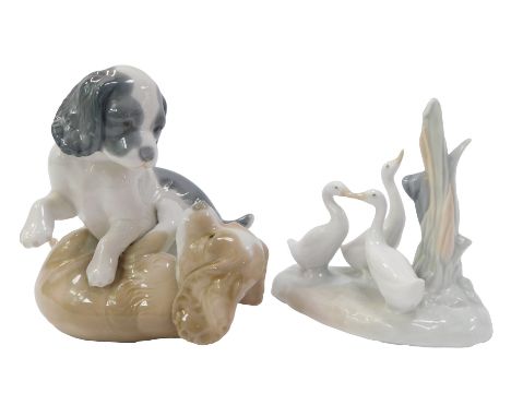Two pieces of Nao porcelain figures, comprising two dogs playing, 13cm high, and a group of geese beside tree bough, 12cm hig