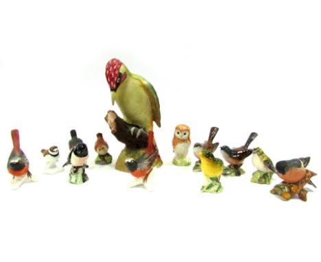 A group of Beswick and other porcelain birds, including a Greenfinch, a Stonechat, together with Goebel birds, a Worcester bi
