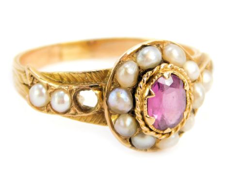 An Edwardian dress ring, the central cluster set with seed pearls around an oval garnet, with seed pearl twist stem shoulders