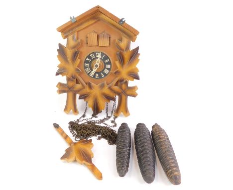 A 20thC pine cased cuckoo clock, with carved leaf decoration, Regula movement, with weights and pendulum, 25cm high. 