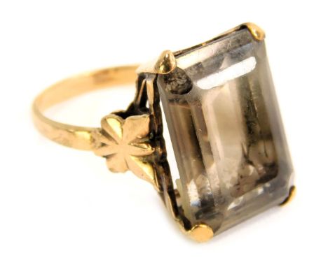 A smokey quartz dress ring, the rectangular cut smokey quartz in a raised basket four claw setting, with floral shoulders, ye