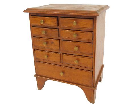 An early 20thC mahogany miniature chest, with an arrangement of nine drawers, on bracket feet, 43cm high, 33cm wide, 24cm dee