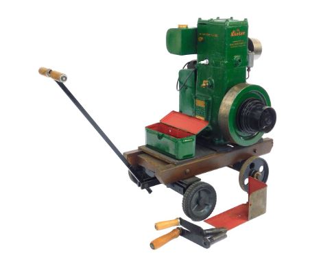A Lister D Type stationery engine, 1.9hp, mounted to a four wheel trolley, with cranking handles, and accessories. (a quantit