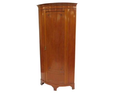 An early 20thC Continental mahogany corner robe, the top with a moulded cornice above a panelled door with floral roundels, e
