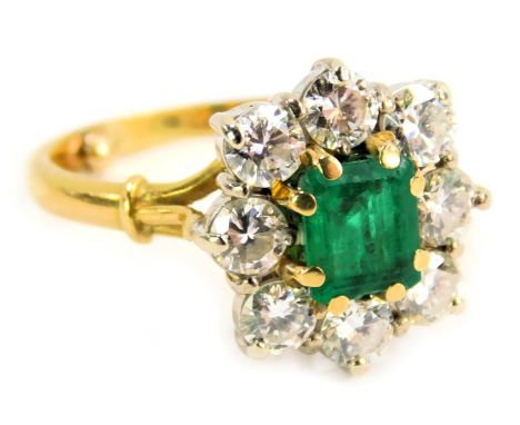 An emerald and diamond cluster ring, the rectangular cut emerald, approx 0.50ct, in eight claw setting surrounded by eight ro