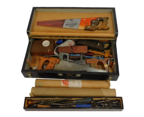 An ebonised tool chest, containing cross-cut saws, hack saws, chisels, auger bits, a sharpening stone, etc.