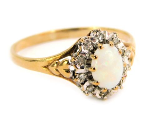 A 9ct gold dress ring, with a central oval opal, surrounded by tiny diamonds in a white gold setting, with V splayed shoulder