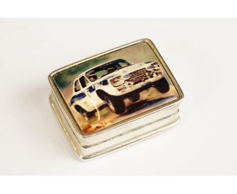 Sterling silver pill box with enamel lid depicting a rally car, approx 3cm wide 