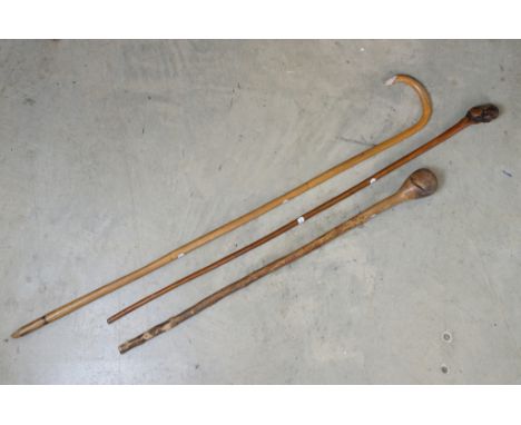 Three vintage wooden walking sticks featuring a knarl-handled examples, bamboo walking stick and a tribal club / walking stic