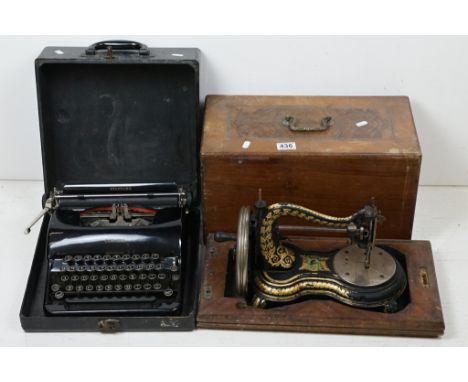 Victorian cast iron table top sewing machine with typical gilt decoration, approx 36cm long, wooden cased; plus a L. C. Smith