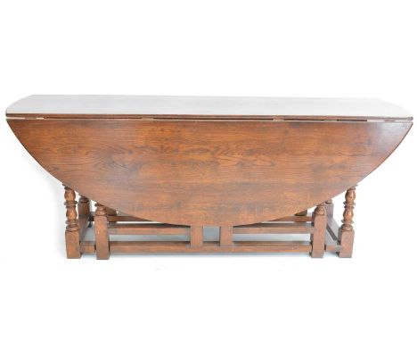 A good quality oak wake table of 18th-century design, oval drop-leaf top supported on ring and bobbin turned double gate leg 