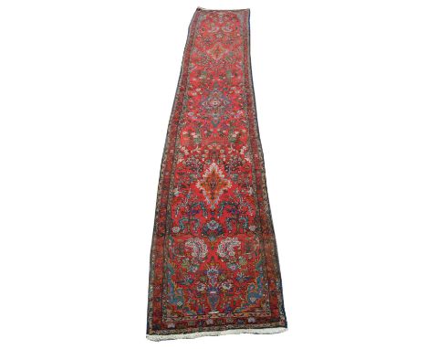 Early 20th-century Sarouk carpet runner, red field with repeating medallion and floral background.460cm (181") x 74cm (29")Co