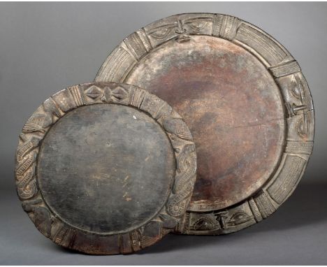 A Yoruba circular divination board the raised border carved with masks 51cm diameter and a smaller divination board with carv