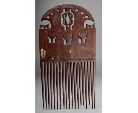 An Ashanti large comb Ghana with carved and pierced decoration including a central knot flanked by two stools and above three