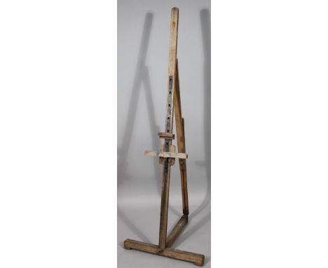 An early 20thC easel, with articulated centre on a T-shaped base, 134cm high.  