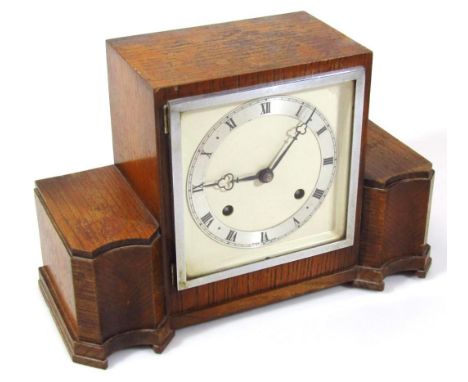 A mid 20thC oak cased mantel clock, the 14cm wide back plate raised with a Roman numeric chapter ring, revealing a pendulum s