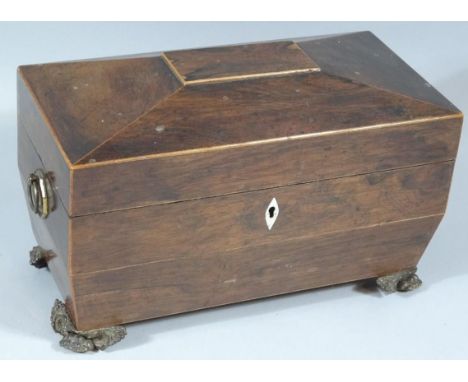 An early 19thC rosewood sarcophagus shaped tea caddy, the hinged lid revealing spaces for mixing bowl, flanked by two compart