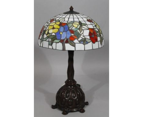 A modern table lamp, with frosted glass floral shade with lead style panelling, on a heavy metal base terminating in shaped f