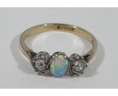 A Victorian opal and diamond dress ring, with central oval opal flanked by two tiny diamonds, yellow metal, marked 18ct plat 