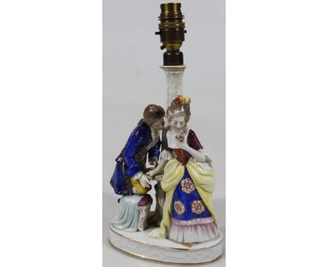 A mid 20thC Sitzendorf porcelain table lamp, formed as a courting couple, each dressed in finery, polychrome decorated in blu