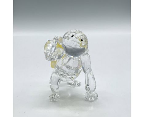 Clear crystal figure holding a bunch of yellow crystal bananas looking at you with black button crystal eyes. Swarovski backs