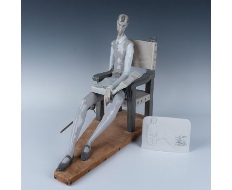 Glossy porcelain figure sitting in chair holding his metal sword with book in his lap. Also includes Lladro Collectors Societ