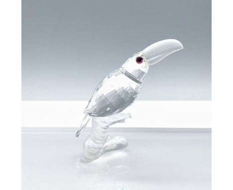 A clear crystal toucan with pink colored eyes, its head slightly raised, accented with frosted crystal for its beak and the b