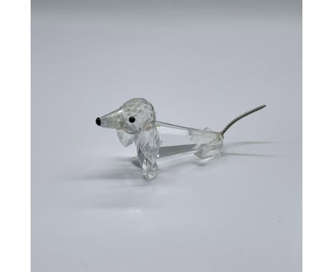 A clear crystal figure of a dog with black crystal eyes and nose. This dog's tail is flexible braided metal. Swarovski Silver