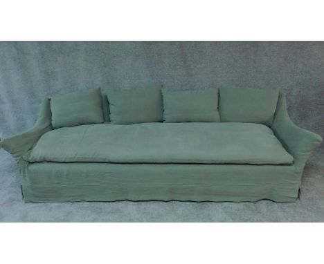 An expansive sofa with large single squab cushion and scatter cushions all feather filled in a sage green fitted covering. H.