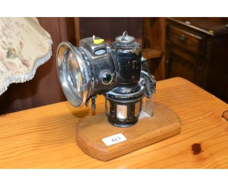 A carbide lamp mounted to wooden base