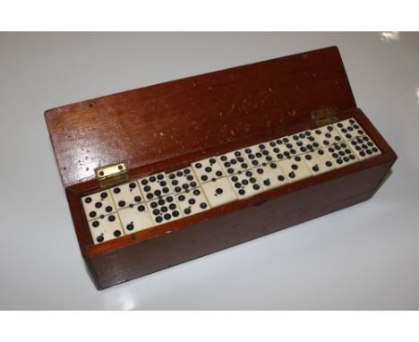 A mahogany cased set of bone dominoes (one missing)