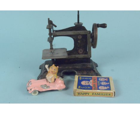 A vintage childs metal sewing machine, a Corgi Miss Piggy vehicle plus Happy Family card game