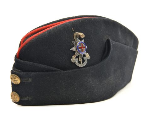 An officer’s blue sidecap of The R Sussex Regt, scarlet piping to top, enamelled silver plated badge, tailor’s label of T.W. 