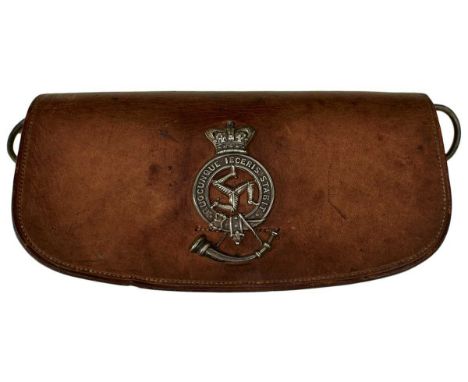 the brown leather pouch applied with a pierced white metal crowned garter QUECUNQUE IECERIS STABIT, central triple leg motif,