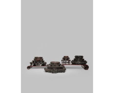 ELEVEN CHINESE HARDWOOD STANDS 19TH/20TH CENTURY Two scroll-shaped, the remaining circular, some with reticulated borders, 34