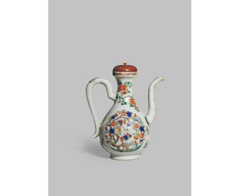 λ A CHINESE FAMILLE VERTE EWER AND COVER KANGXI 1662-1722 The pear-shaped body decorated with roundels of prunus and other st