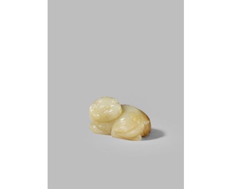 A CHINESE CELADON JADE CARVING OF A LION DOG MING DYNASTY OR LATER Recumbent with its head turned and facing backwards, the s