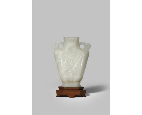 A CHINESE PALE CELADON JADE ARCHAISTIC FLATTENED VASE QING DYNASTY The V-shaped body carved in shallow relief with masks on a