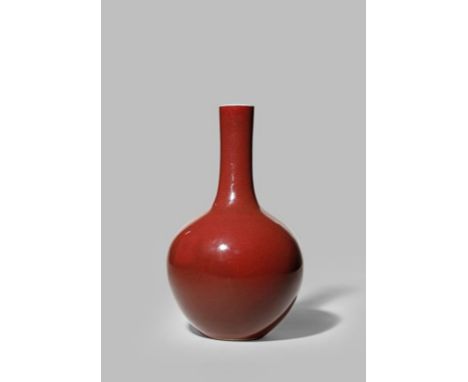 A CHINESE BOTTLE VASE 20TH CENTURY With a tall slender neck rising from an ovoid body, decorated with an even ox-blood glaze,