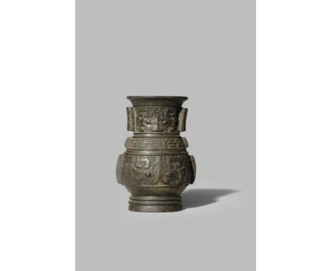 A SMALL CHINESE BRONZE ARCHAISTIC VASE 17TH CENTURY The pear-shaped body with flanges to each side, decorated in relief with 