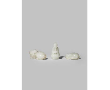 THREE CHINESE PALE CELADON JADE CARVINGS QING DYNASTY OR LATER Two formed as reclining Buddhist lion dogs with their heads tu