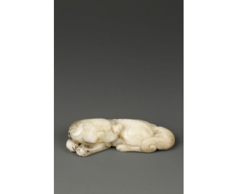 A CHINESE OPAQUE PALE CELADON JADE RECUMBENT LION, the creature with its' head turned to the rear, the vertebrae, tail and ma