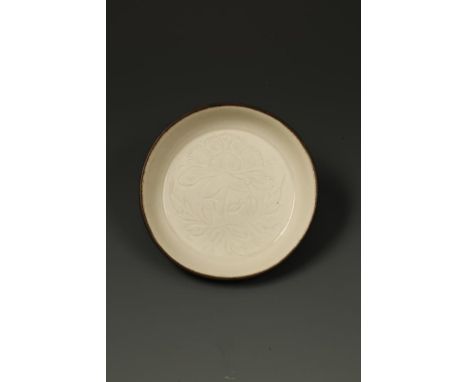 A FINE CHINESE DINGYAO SHALLOW WASHER, the centre carved with a peony flower and foliage, the sides tapering and gently round