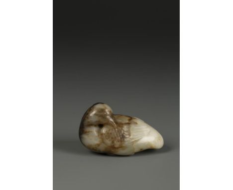 A CHINESE MOTTLED JADE BIRD, the creature with its head turned backwards and carved feather details, the underside also carve