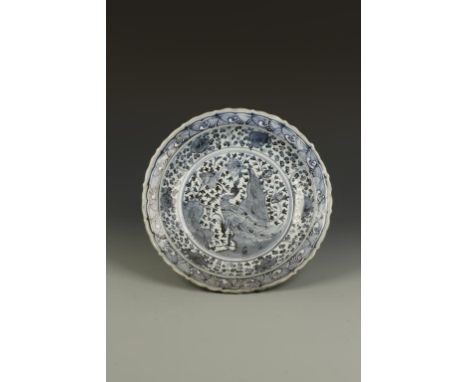 A CHINESE BLUE AND WHITE BARBED-RIM DISH, the centre decorated with a peacock in a rocky garden within a flower and scroll ca