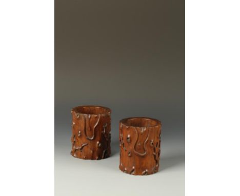 A PAIR OF CHINESE HUANGHUALI TRUNK-FORM BRUSH POTS naturalistically carved with gnarls and branches, the well-patinated wood 