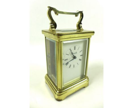 A 20th century carriage clock, of conventional form with glazed brass case, white face with Roman numerals and 'Harrods', wit